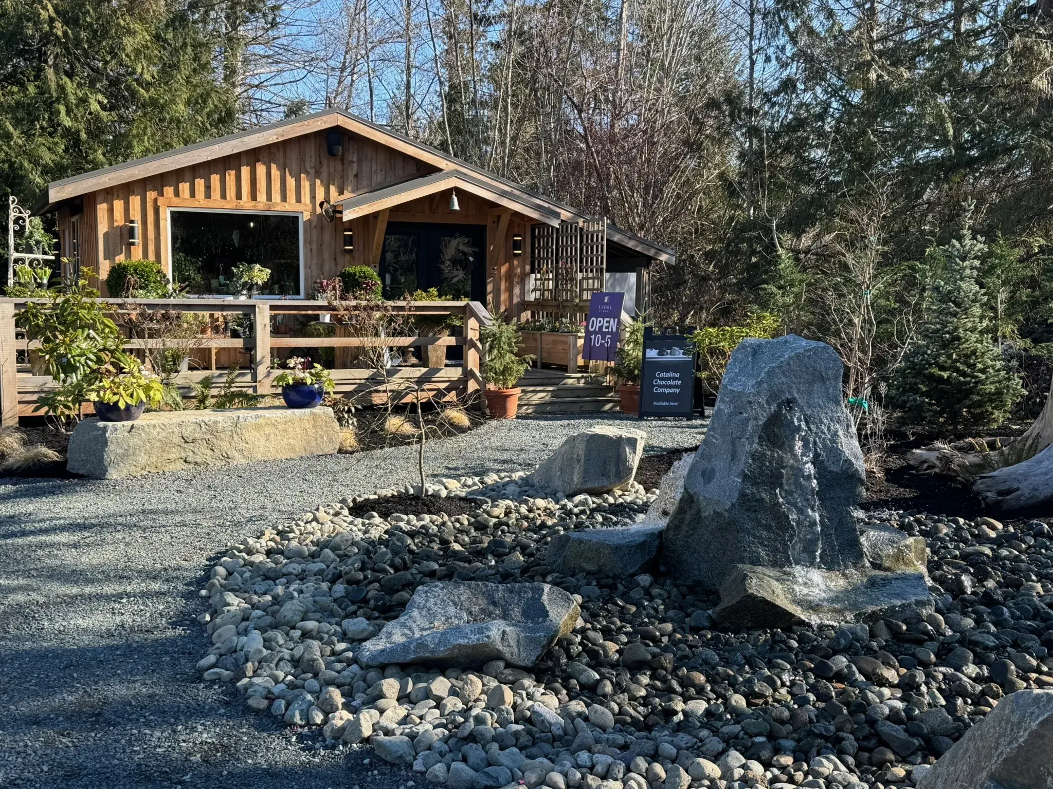 Drilled basalt boulder fountain set in a bed of river rock