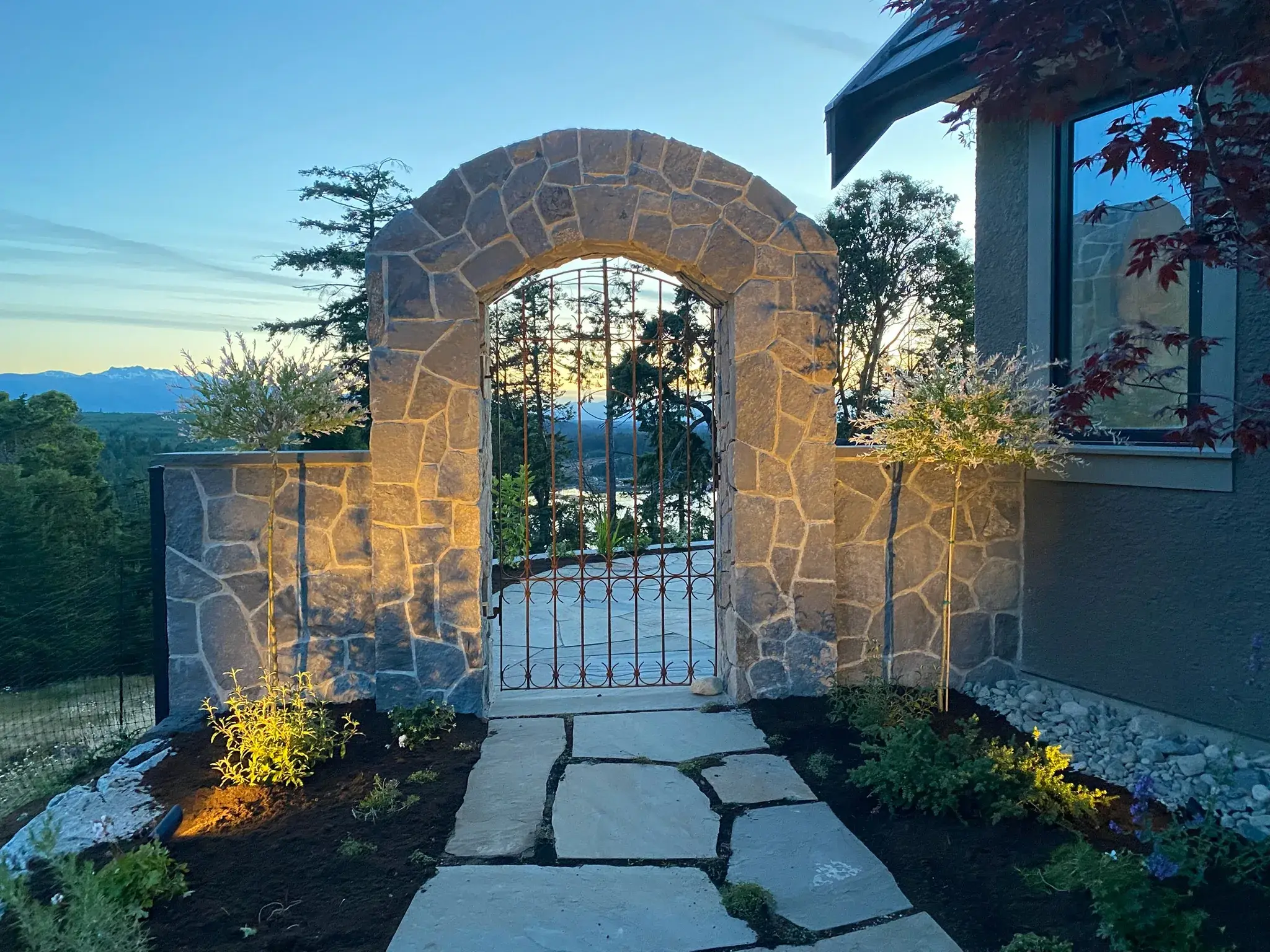 Uplit stone archway and flagstone path at dusk
