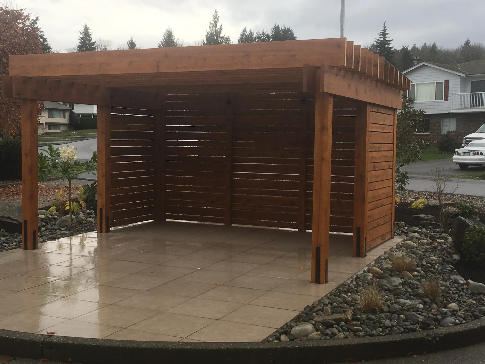 Cedar shade structure with slatted privacy walls on a paver patio