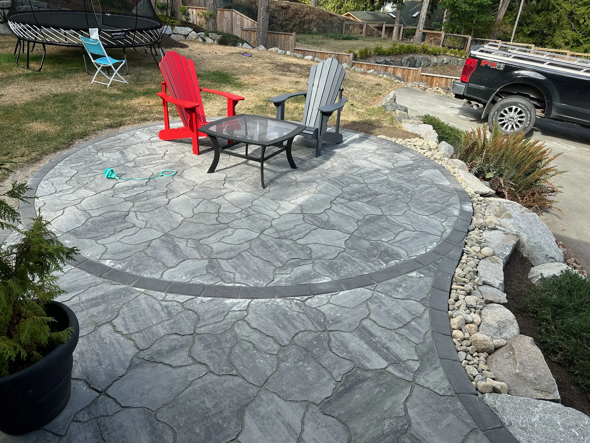 Flagstone patio with Adirondack chairs and a low table
