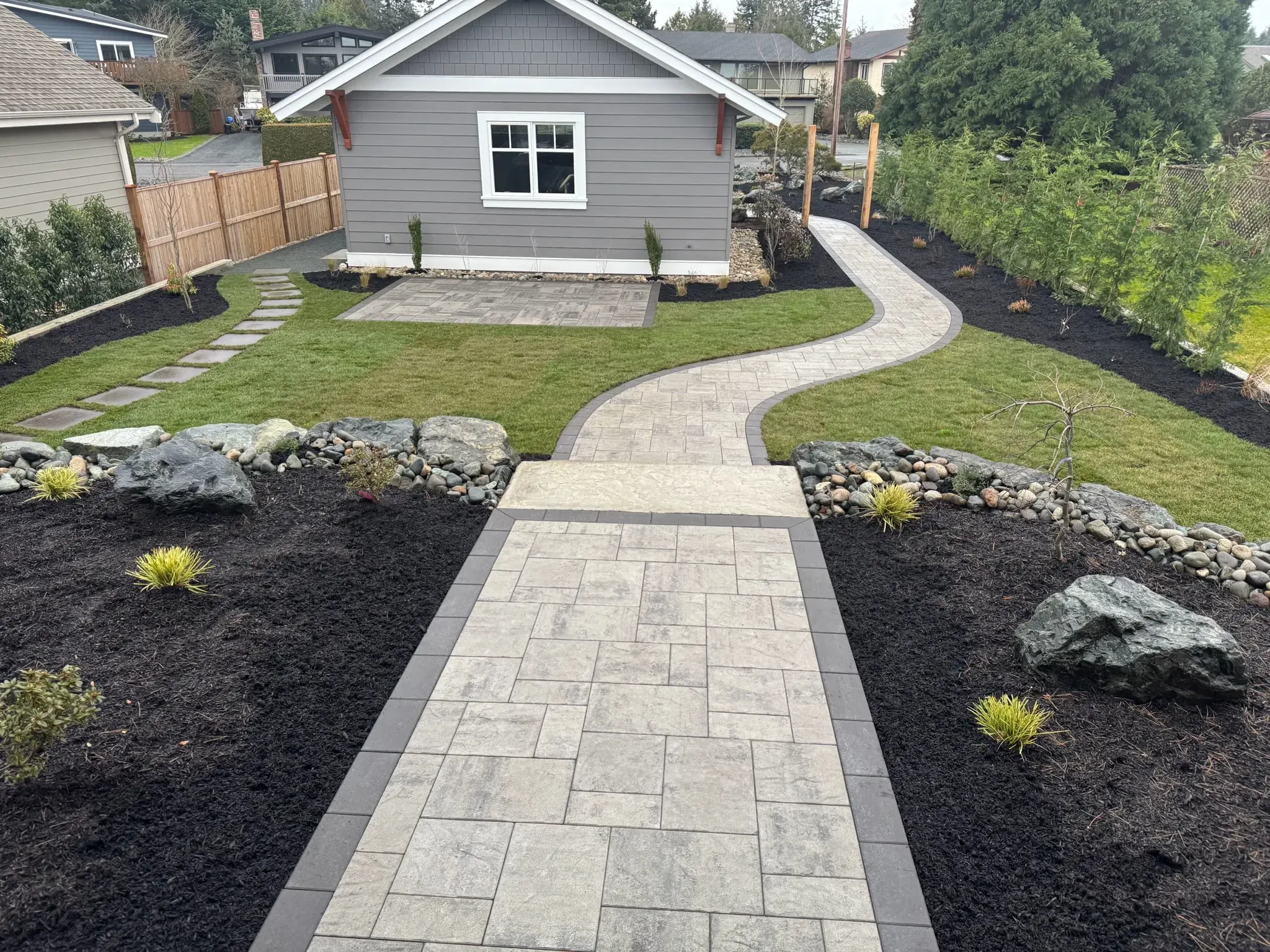 Paver walkway leading to a new home with freshly mulched beds