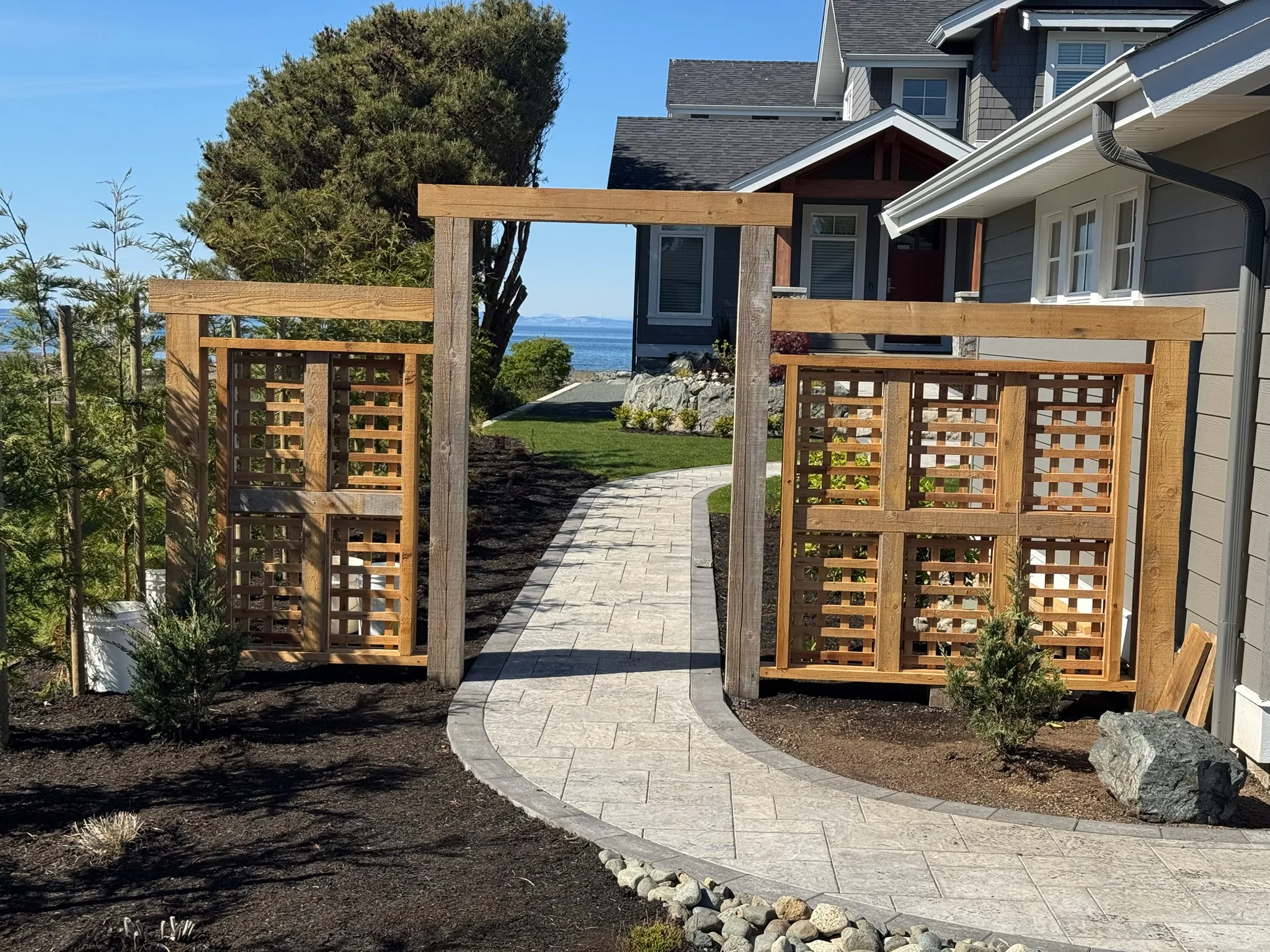 Cedar privacy screens beside a paver walkway