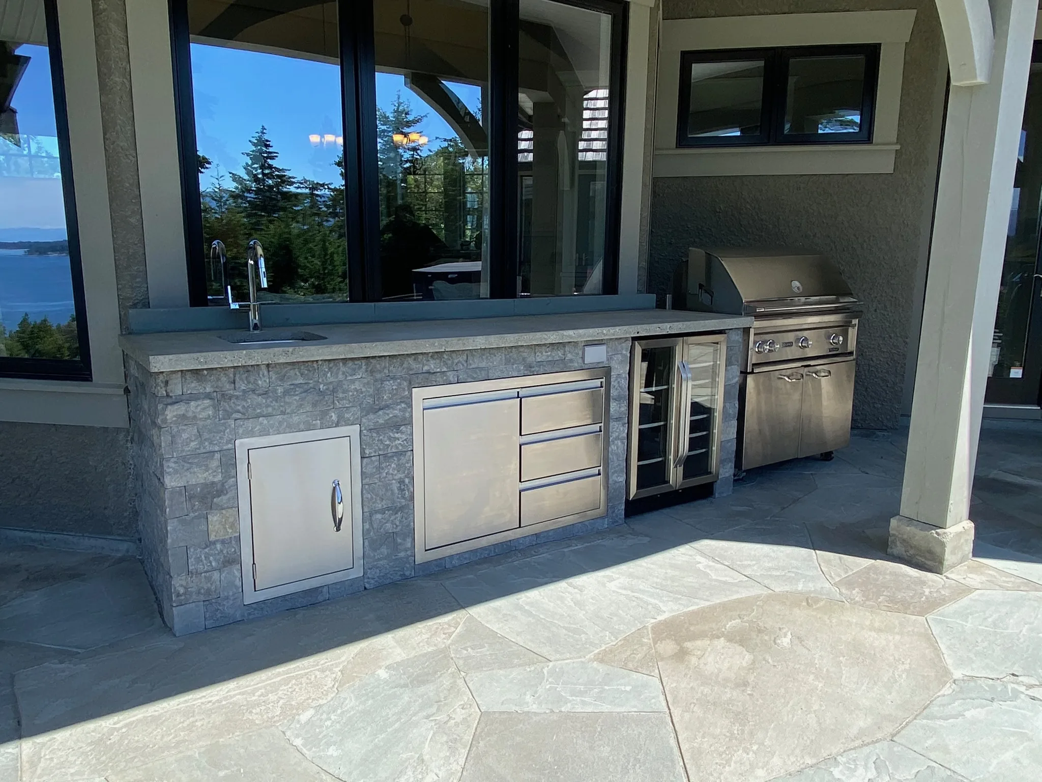 Stone-clad outdoor kitchen island on a flagstone terrace