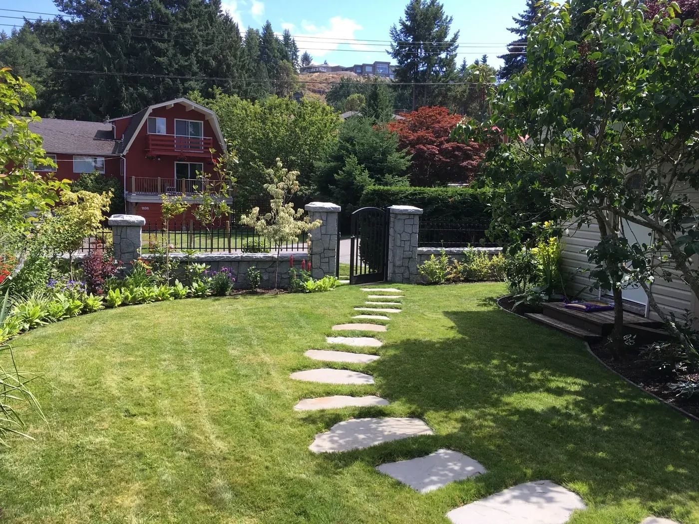 Stepping-stone path set through a lawn with planted borders