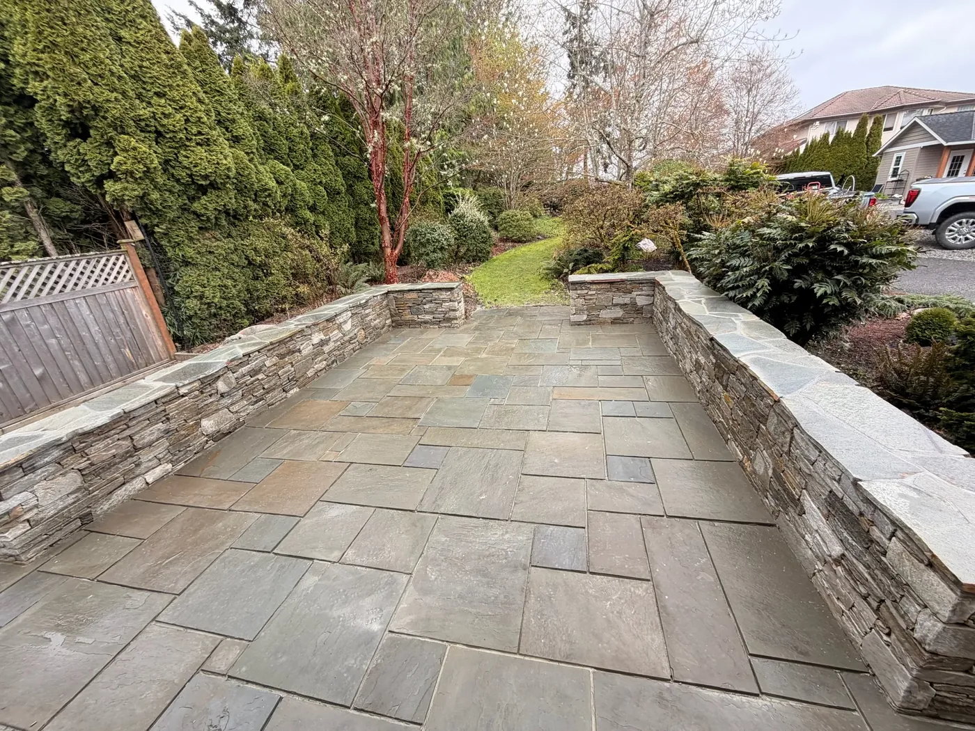 Cut flagstone terrace framed by hand-laid stone retaining walls