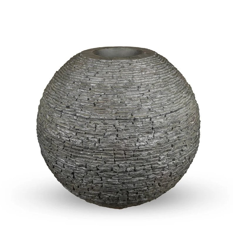 Stacked slate sphere installed in a garden