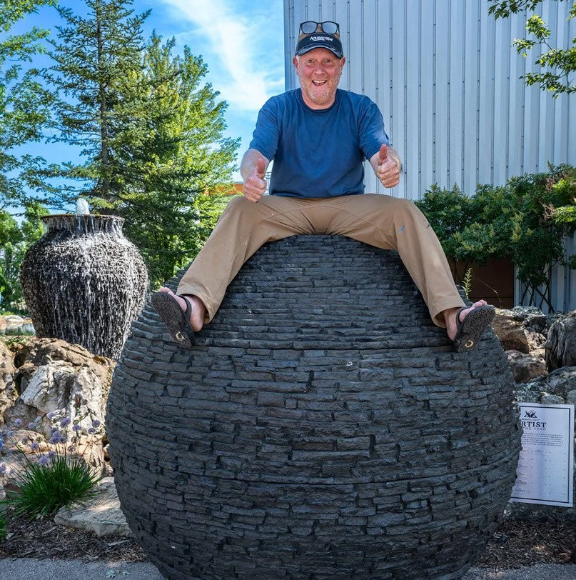 Water cascading over stacked slate sphere